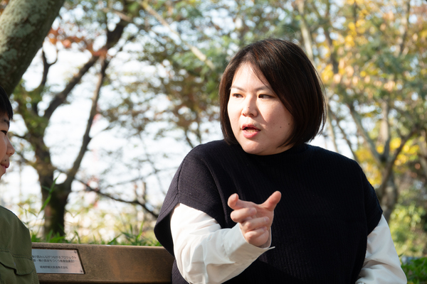 キッズ向けサングラスを子供が装着した感想を話しているお母さんが公園のベンチで座っている
