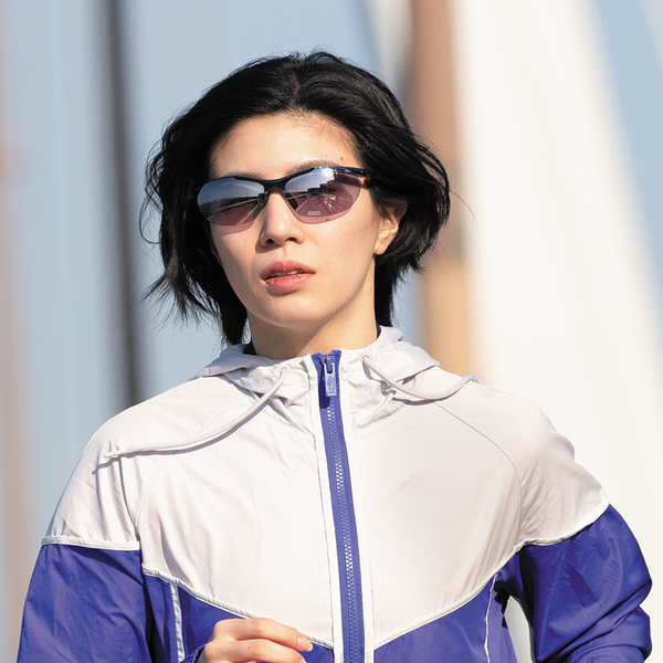 Runner wearing SWANS Airless-Core ultra-light sunglasses on a city run